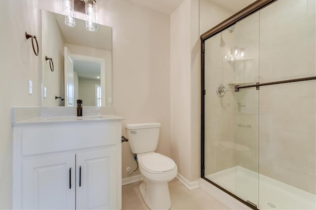 bathroom featuring toilet, a shower stall, baseboards, and vanity