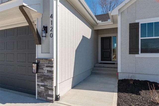 property entrance featuring a garage and stone siding