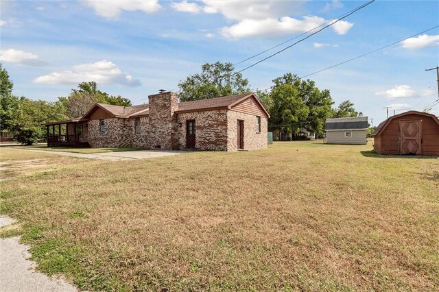 view of front of house with a front yard and a shed