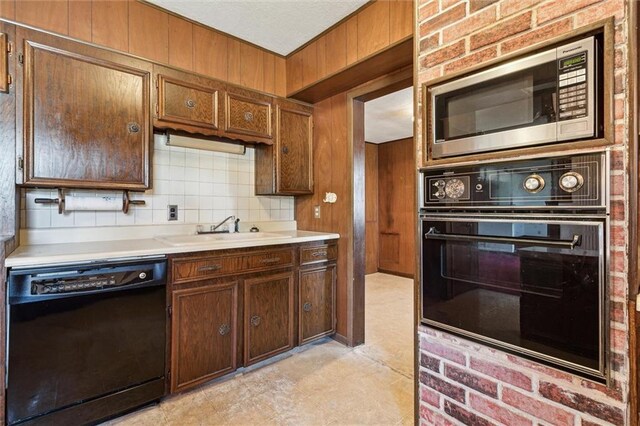 kitchen with black appliances, sink, and backsplash