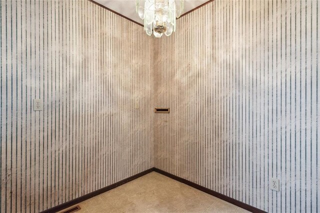 unfurnished room with wood walls and a chandelier