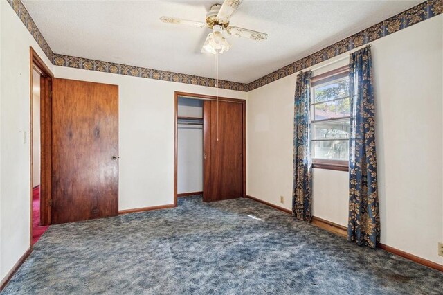 unfurnished bedroom featuring dark carpet, a closet, and ceiling fan