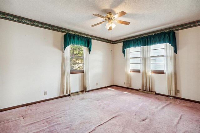 carpeted spare room featuring a textured ceiling and ceiling fan