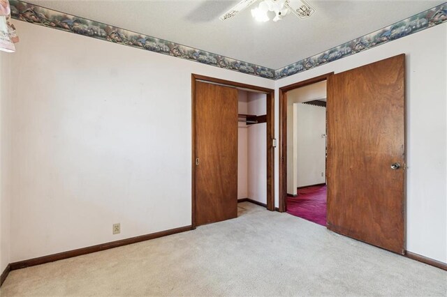 unfurnished bedroom with light carpet, ceiling fan, and a closet