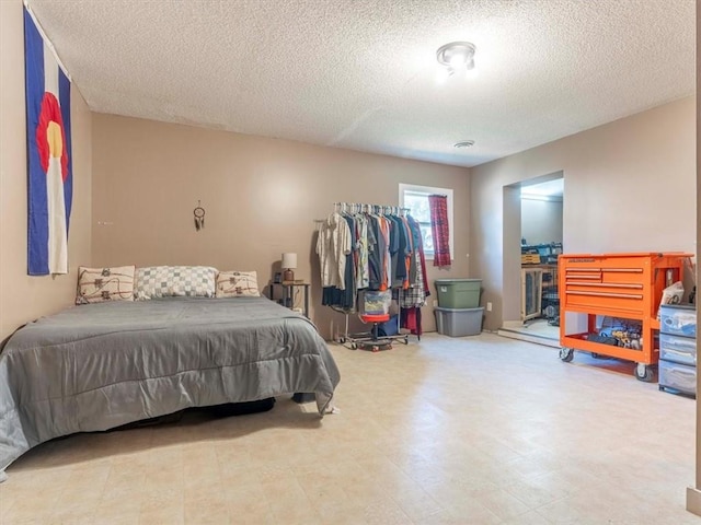 bedroom featuring a textured ceiling and light tile patterned floors