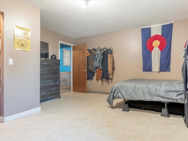 bedroom with a textured ceiling and light tile patterned floors