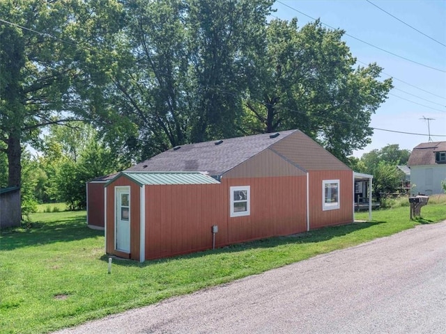 view of side of home featuring an outdoor structure and a yard