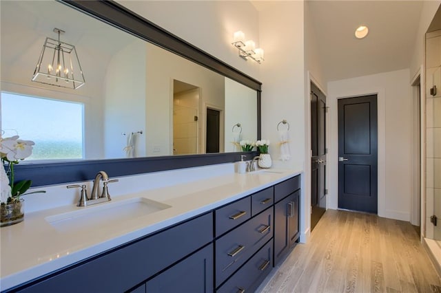 bathroom featuring wood-type flooring, vanity, and a chandelier