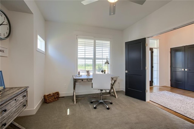 office space featuring ceiling fan, baseboards, and light colored carpet