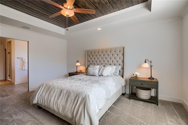 carpeted bedroom with ornamental molding, wooden ceiling, a raised ceiling, and ceiling fan