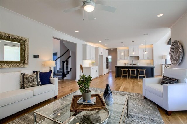 living room with hardwood / wood-style floors, crown molding, and a wealth of natural light