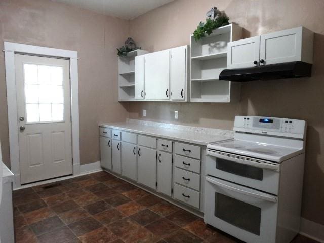 kitchen featuring white electric range, dark tile patterned floors, and white cabinets