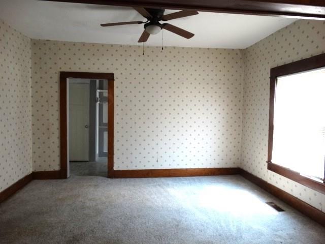 spare room featuring ceiling fan and carpet flooring