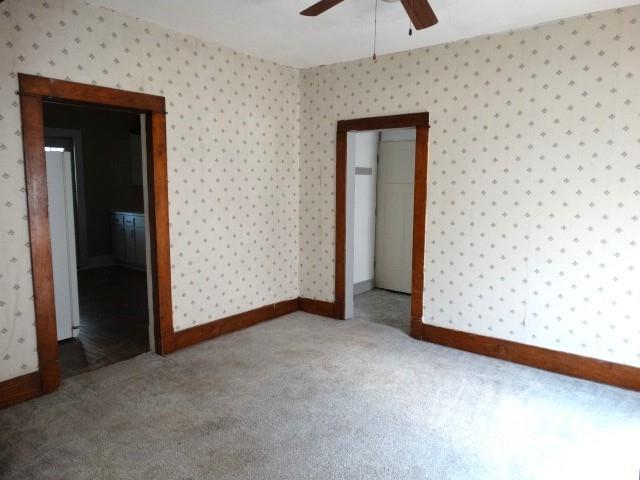 carpeted spare room with ceiling fan