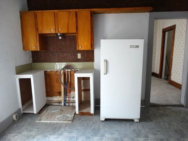 kitchen featuring decorative backsplash, white fridge, and light tile patterned floors