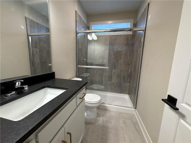 bathroom featuring vanity, toilet, and an enclosed shower