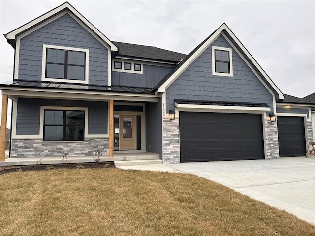 view of front of home with a garage, a front yard, and covered porch