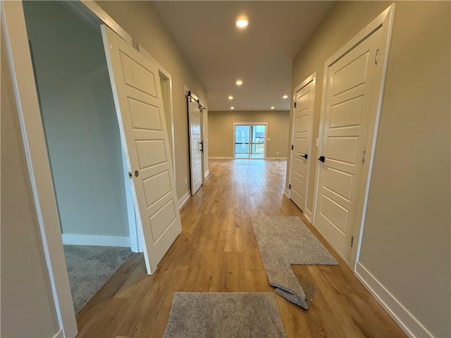 hallway with light hardwood / wood-style floors