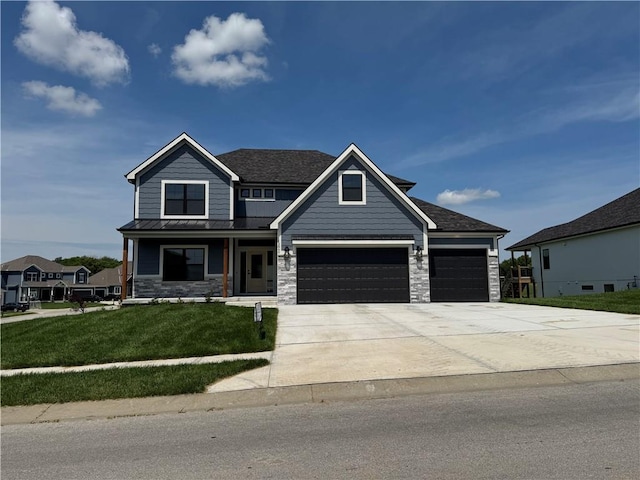 12860 N Champanel Way, Platte City, MO 64079 - view of front of home with a front yard, stone siding, concrete driveway, a standing seam roof, and a metal roof