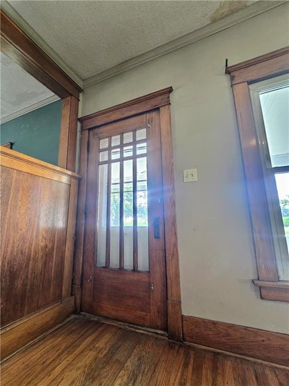 foyer entrance featuring ornamental molding, a textured ceiling, and hardwood / wood-style floors