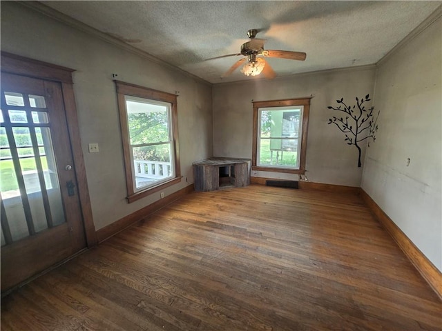 interior space featuring a textured ceiling, ceiling fan, wood-type flooring, and a healthy amount of sunlight