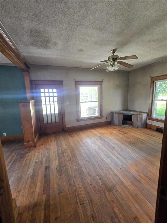 unfurnished living room with a textured ceiling, ceiling fan, and wood-type flooring