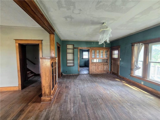 unfurnished living room featuring dark wood-type flooring and a textured ceiling