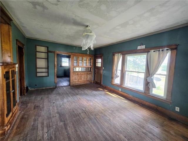 unfurnished living room featuring dark wood-type flooring and a textured ceiling