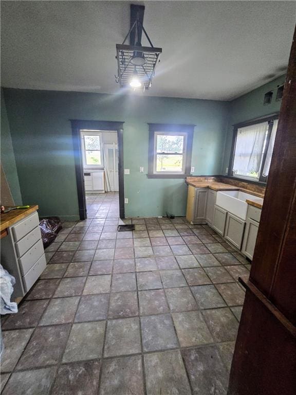 kitchen featuring butcher block countertops, sink, and light tile patterned floors