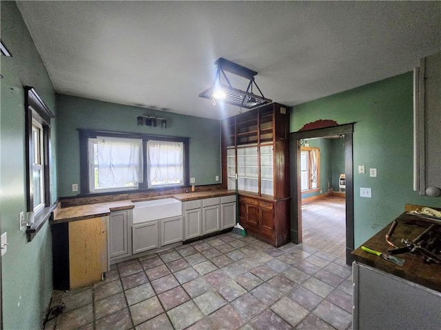 kitchen with white cabinetry, wood counters, light tile patterned floors, and a textured ceiling