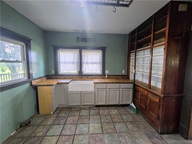 kitchen with sink, tile patterned flooring, and white cabinets