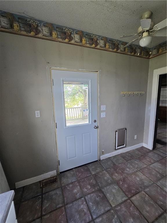 entryway with ceiling fan and dark tile patterned flooring