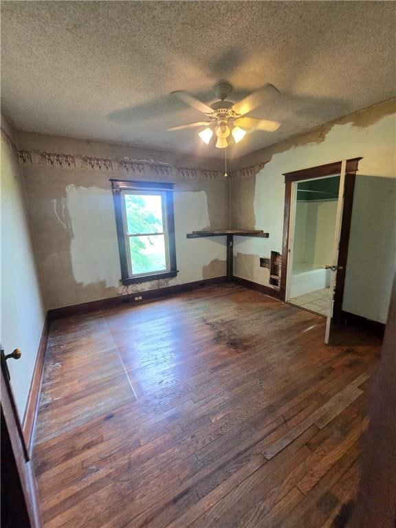 unfurnished bedroom with hardwood / wood-style flooring, a textured ceiling, and ceiling fan