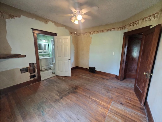 unfurnished bedroom featuring ensuite bath, sink, tile patterned flooring, and ceiling fan