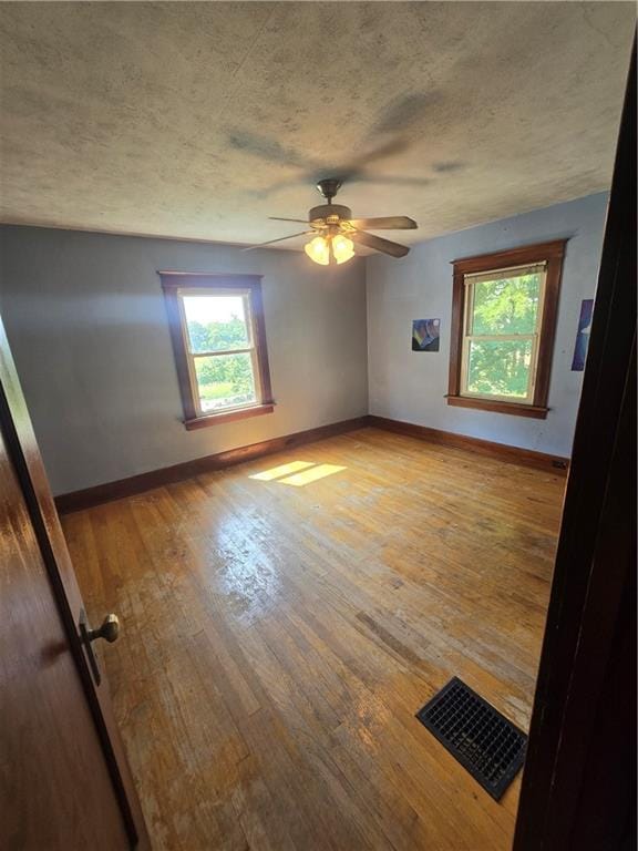 spare room with ceiling fan and light wood-type flooring