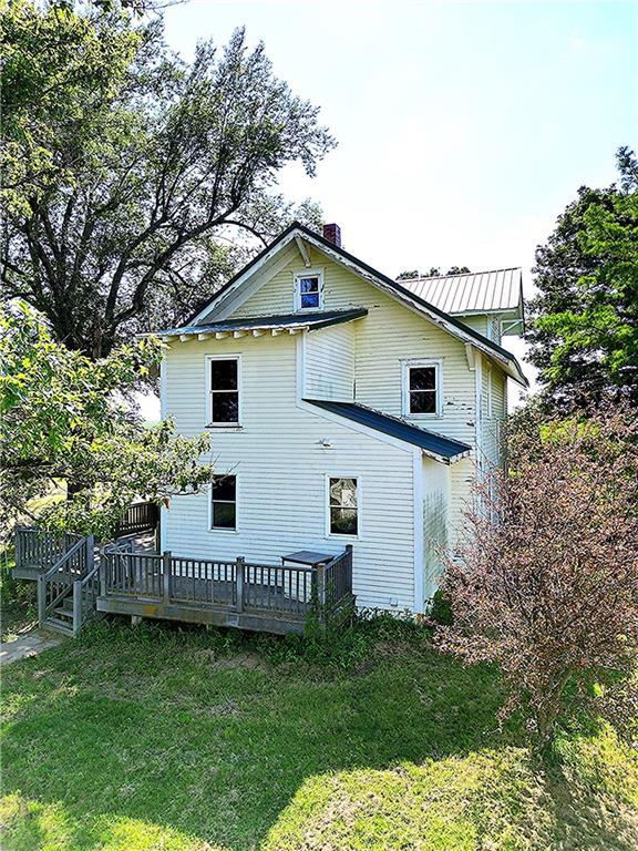 back of house with a wooden deck and a lawn