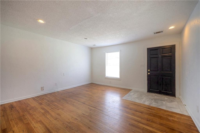 entrance foyer featuring a textured ceiling and light hardwood / wood-style flooring