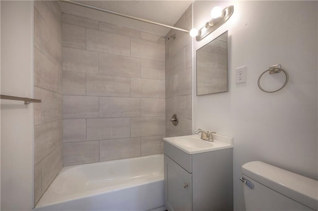 full bathroom featuring vanity, tiled shower / bath, and toilet