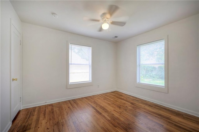 spare room featuring ceiling fan, plenty of natural light, and wood-type flooring