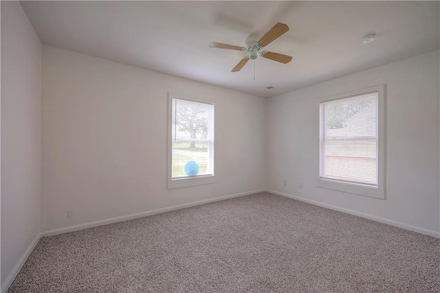 carpeted spare room featuring ceiling fan