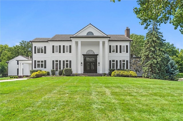 neoclassical / greek revival house featuring a front yard