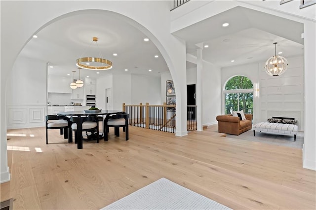 dining area featuring a large fireplace, light hardwood / wood-style flooring, and a chandelier