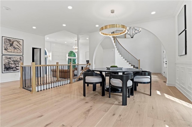 dining area with light hardwood / wood-style floors and a chandelier