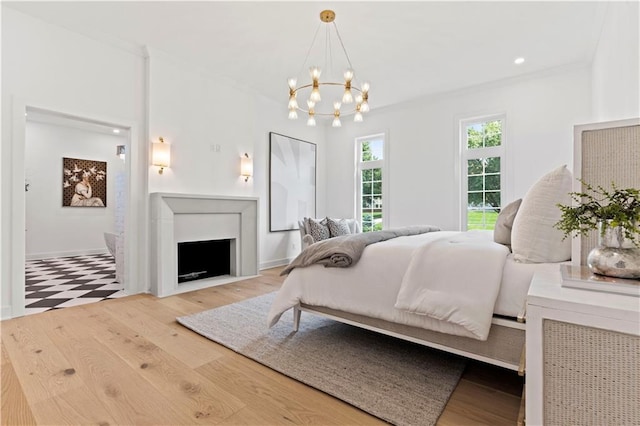 bedroom with light hardwood / wood-style floors and a chandelier