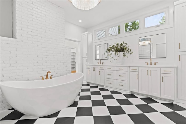 bathroom with vanity, a bathing tub, and brick wall