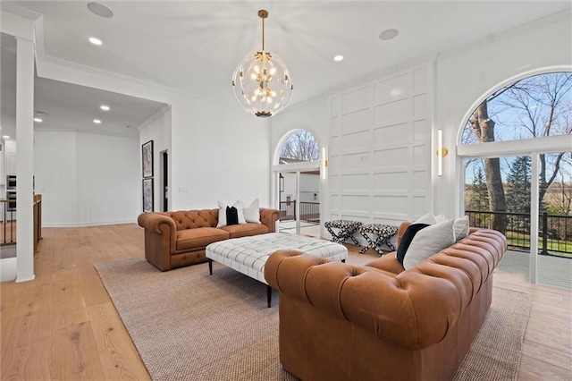 living room featuring ornamental molding, light hardwood / wood-style floors, and a notable chandelier