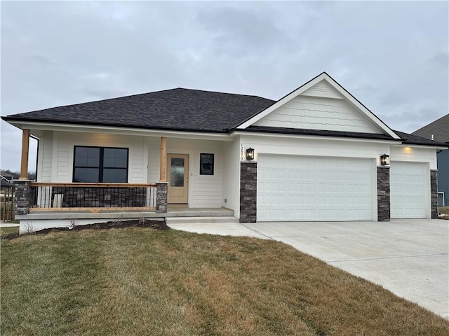 view of front of property with a porch, a garage, and a front lawn