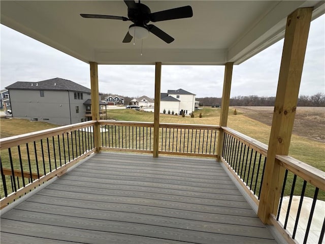 wooden terrace featuring a lawn and ceiling fan