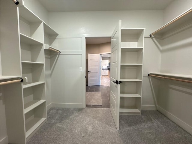 spacious closet featuring dark colored carpet