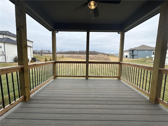 wooden deck with a lawn and ceiling fan